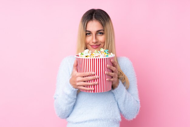 Junge uruguayische Frau, die einen großen Eimer Popcorn hält