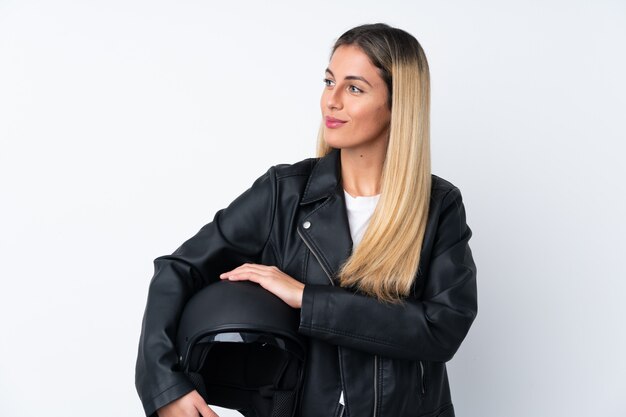 Junge uruguayische Frau mit einem Motorradhelm, der zur Seite schaut