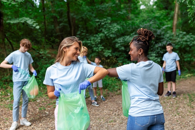 Junge verantwortungsbewusste Menschen, die im Park gemeinnützige Arbeit leisten Gruppe von Menschen, die gemeinsam im öffentlichen Park putzen und die Umwelt retten