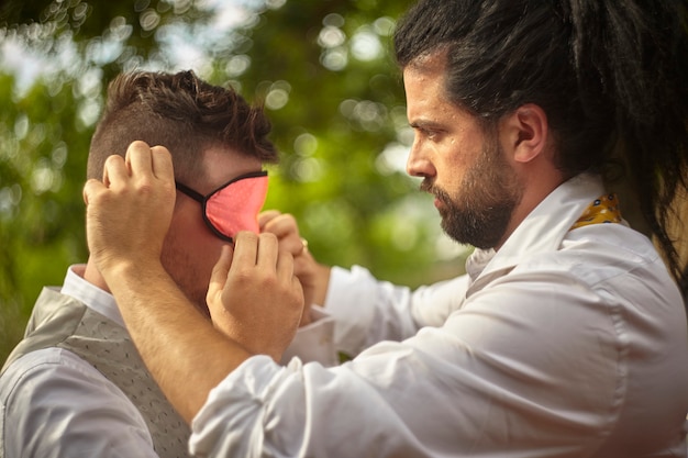 Junge verbindet einem anderen Jungen die Augen für ein Spiel im Freien