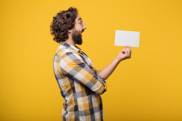 Junge verrückte verrückte Manndummkopfhaltung, die ein Plakat hält