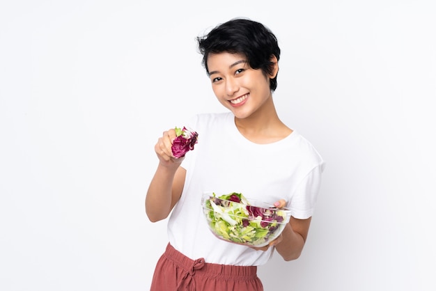 Junge vietnamesische Frau mit den kurzen Haaren, die einen Salat halten