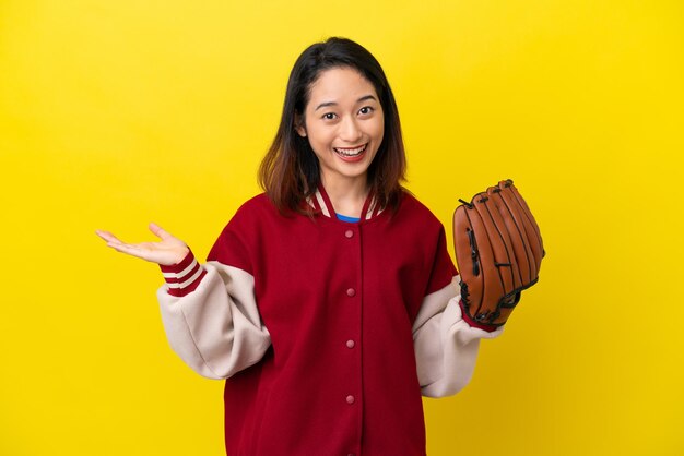 Junge vietnamesische Spielerin mit Baseballhandschuh isoliert auf gelbem Hintergrund mit schockiertem Gesichtsausdruck