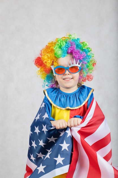 Junge von fünf Jahren, gekleidet in das Kostüm eines Clowns mit amerikanischer Flagge.Nahaufnahme