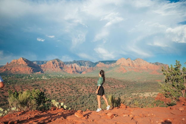 Junge Wandererin am Rande einer Klippe am Cathedral Rock in Sedona, Arizona Aussicht von Scenic Cathedral Rock in sedona mit blauem Himmel in Arizona