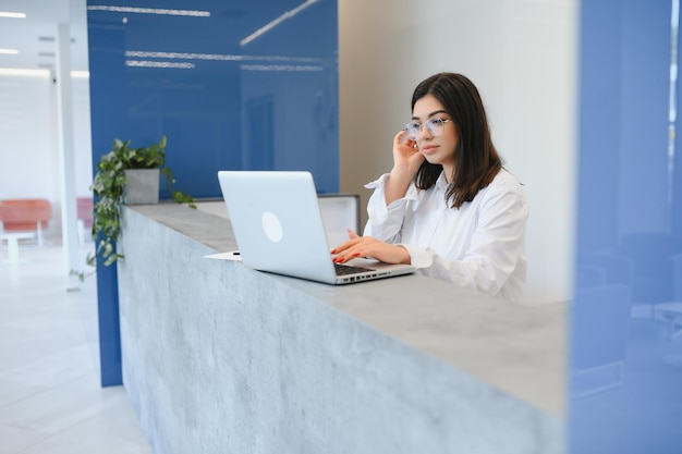 Junge weibliche Empfangsdame, die im Büro arbeitet