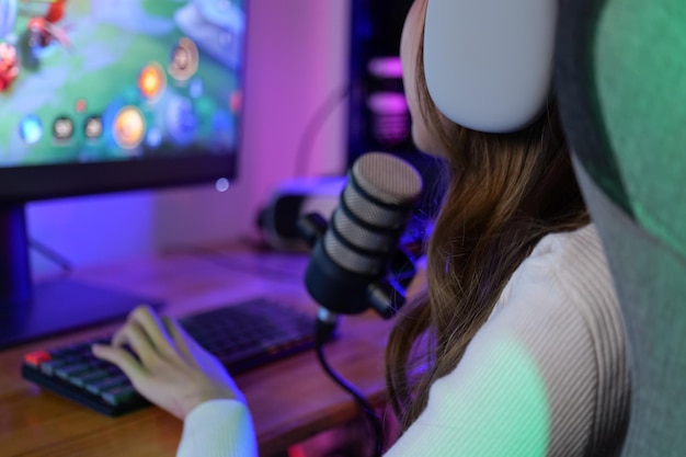 Junge weibliche Game-Streamerin spielt zu Hause ein Online-Spiel am Computer