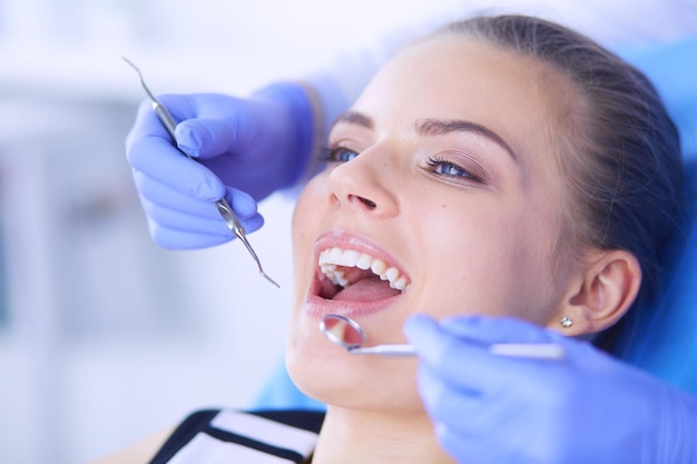 Junge weibliche Patientin mit offenem Mund untersucht die zahnärztliche Untersuchung in der Zahnarztpraxis