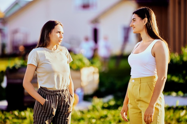 Junge weiße Frauen sprechen im Sommer auf der Straße eines Vorstadtdorfes