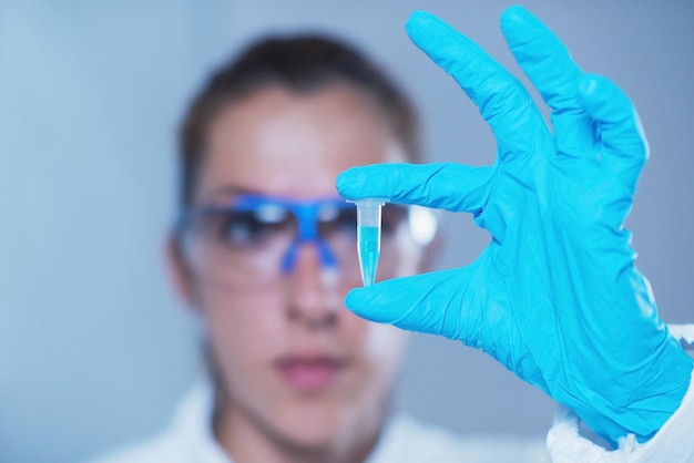 Junge Wissenschaftlerin hält Mikroreagenzglas in der Hand