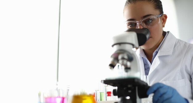 Junge Wissenschaftlerin untersucht das Mikroskop im Labor
