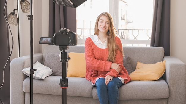 Junge youtuber oder Bloggerin, die Inhalt für soziale Medien erstellt, während sie ein Video zu Hause macht