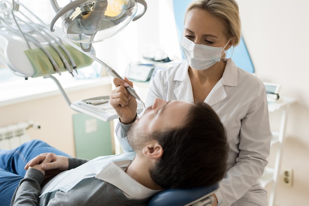 Junge Zahnärztin, die Patientin behandelt