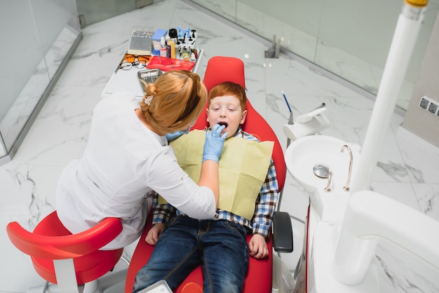Junge zufrieden mit dem service in der zahnarztpraxis. konzept der pädiatrischen zahnbehandlung