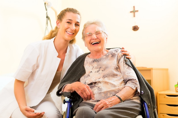 Jungekrankenschwester und weiblicher Senior im Pflegeheim