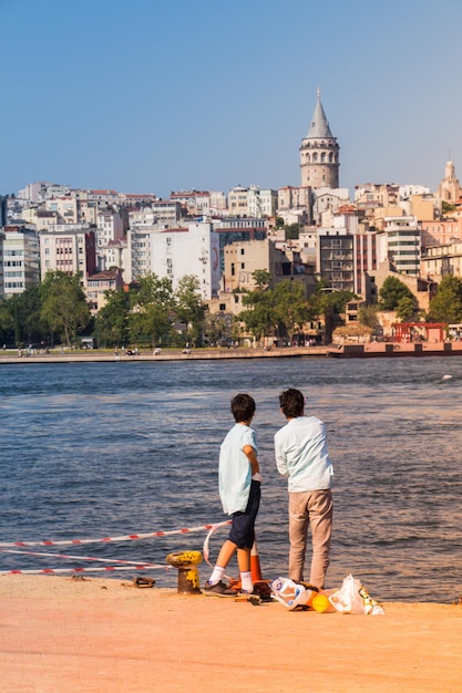 Jungen am Meer in Istanbul mit Blick auf das Stadtmeer und den Galata-Turm