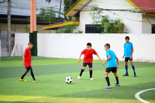 Jungen, die Fußball auf dem Fußballtrainingsfeld spielen