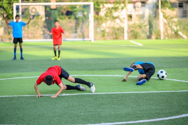 Jungen, die Fußball auf dem Fußballtrainingsfeld spielen