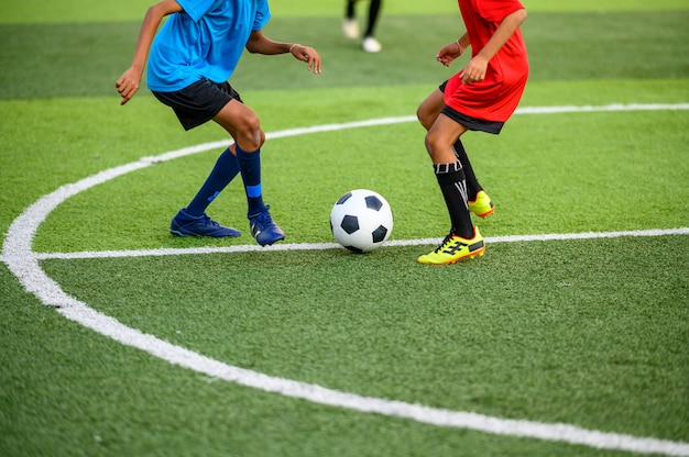 Jungen, die Fußball auf dem Fußballtrainingsfeld spielen