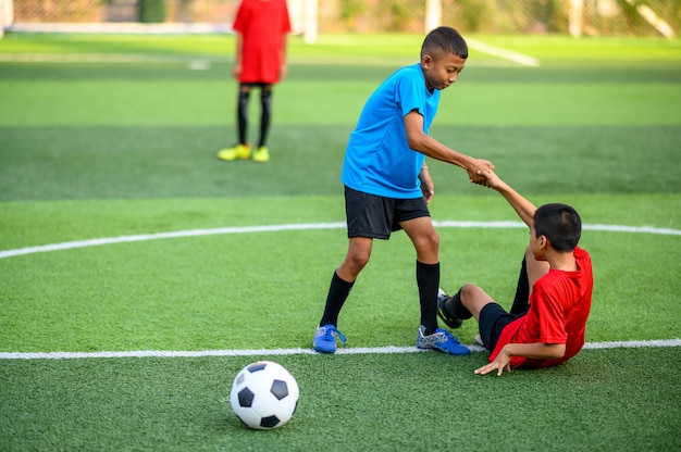 Jungen, die Fußball auf dem Fußballtrainingsfeld spielen