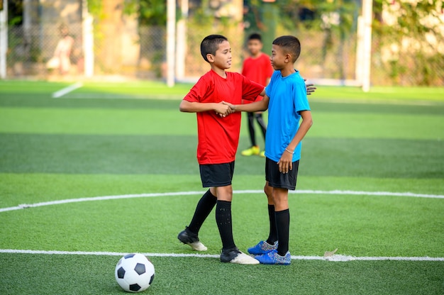 Jungen, die Fußball auf dem Fußballtrainingsfeld spielen