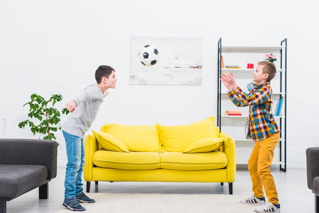 Foto jungen, die fußball im wohnzimmer spielen