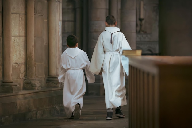 Jungen in weißer Tunika während der Kommunion in der Kirche