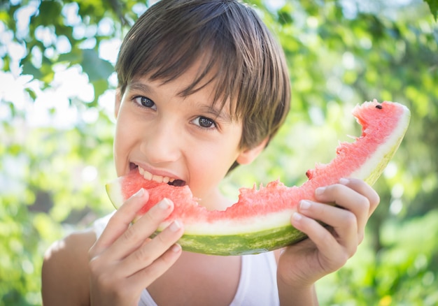 Jungen mit der Wassermelone Sommer genießend