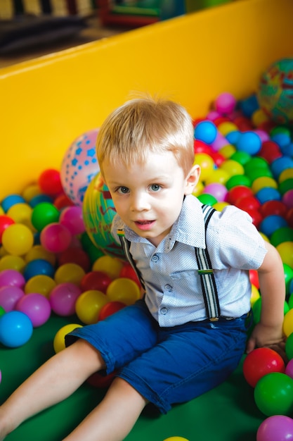 Jungen spielen auf dem Spielplatz, im Kinderlabyrinth mit Bällen. Mehrfarbige Kugeln