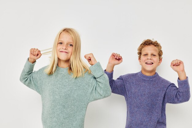 Jungen und Mädchen posieren auf weißem Hintergrund und lächeln