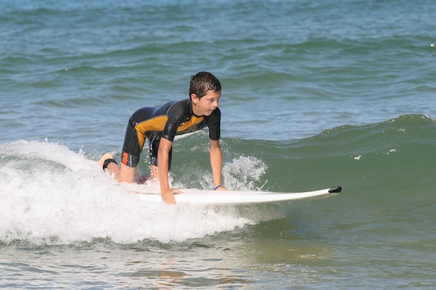 Jungensurfer, der Wellen surft