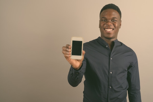junger afrikanischer Geschäftsmann mit Handy