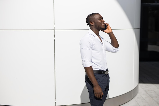 Junger afrikanischer Geschäftsmann ruft am Telefon an