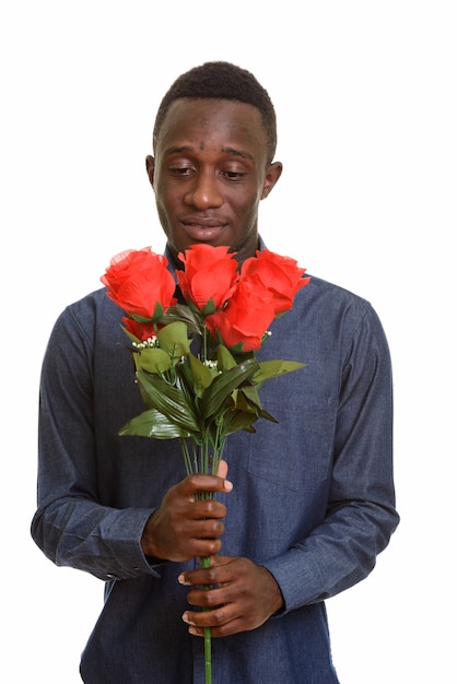 Junger afrikanischer Mann, der rote Rosen bereit für Valentinstag hält