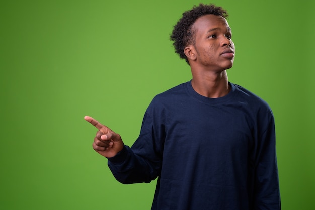 Junger afrikanischer Mann gegen grüne Wand