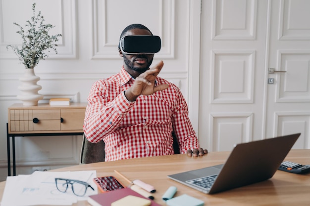 Junger afrikanischer Unternehmer mit VR-Headset-Brille, eingetaucht in d-Gaming