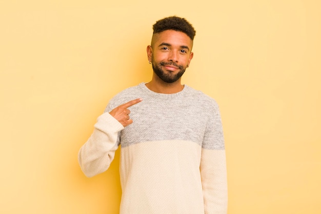 Junger Afro-Mann, der stolz, selbstbewusst und glücklich aussieht, lächelt und auf sich selbst zeigt oder das Zeichen Nummer eins macht