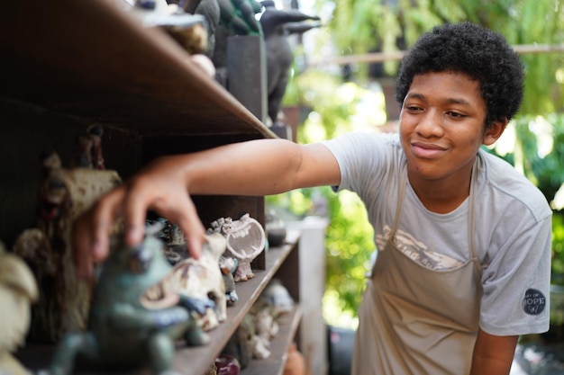 Junger Afro-Mann-Handtöpfer, der Tonvase in der Töpferwerkstatt herstellt, Geschäftsinhaber.