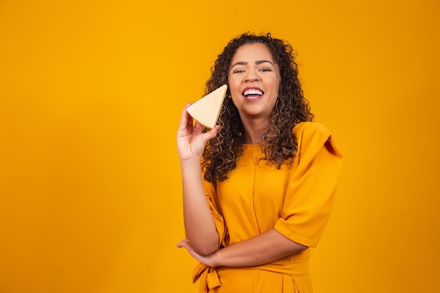 Junger Afro-Mann mit einer Scheibe Brie-Käse in seinen Händen. Junge Frau, die Käse isst