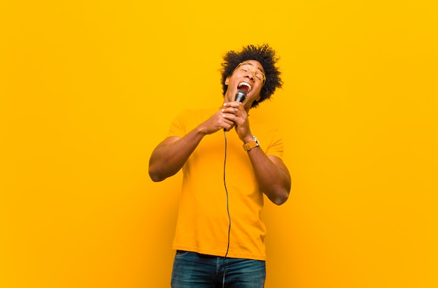 Junger Afroamerikanermann mit einem Mikrofon singend