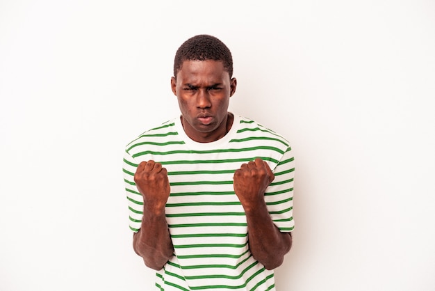 Junger afroamerikanischer Mann isoliert auf weißem Hintergrund, der Faust zur Kamera zeigt, aggressiver Gesichtsausdruck.