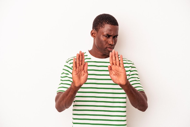 Junger afroamerikanischer Mann isoliert auf weißem Hintergrund, der mit ausgestreckter Hand mit Stoppschild steht und Sie daran hindert.