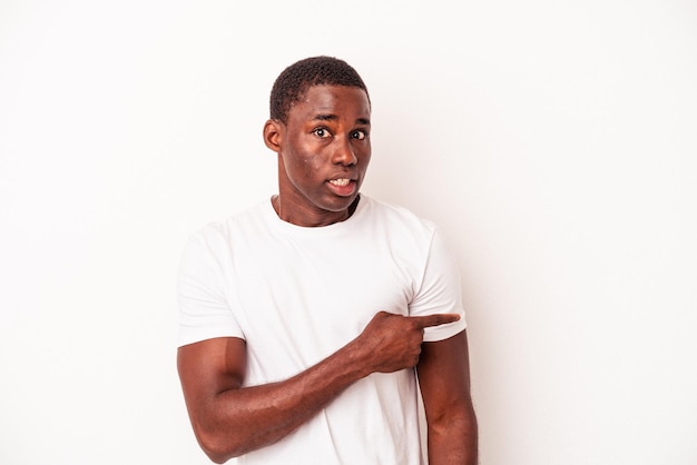 Junger afroamerikanischer Mann isoliert auf weißem Hintergrund, der zur Seite zeigt