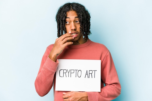 Junger afroamerikanischer Mann mit Krypto-Art-Plakat isoliert auf blauem Hintergrund dachte entspannt über etwas nach und betrachtete einen Kopierraum