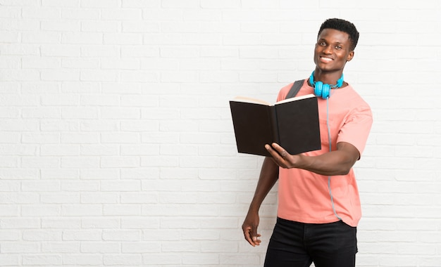 Junger afroer-amerikanisch Mannstudent, der ein Buch liest