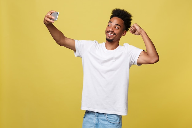 Junger afroer-amerikanisch schwarzer Mann, der glückliches nehmendes selfie Selbstporträtbild lächelt