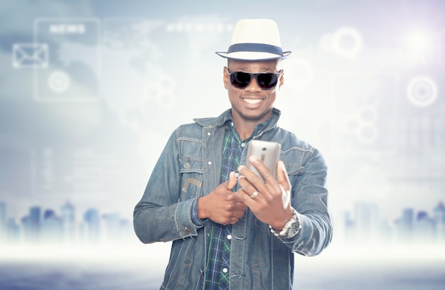 Junger amerikanischer Afrikaner mit Handy. Schöner Mann. Konzept des Geräts, das Menschen verbindet