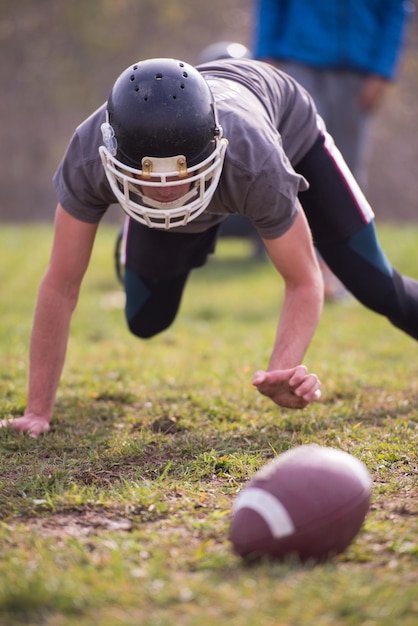 junger amerikanischer fußballspieler in aktion während des trainings auf dem feld