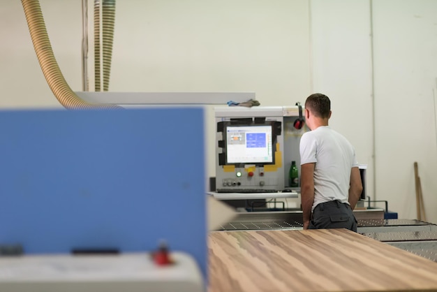 Junger Arbeiter arbeitet in einer Fabrik zur Herstellung von Holzmöbeln