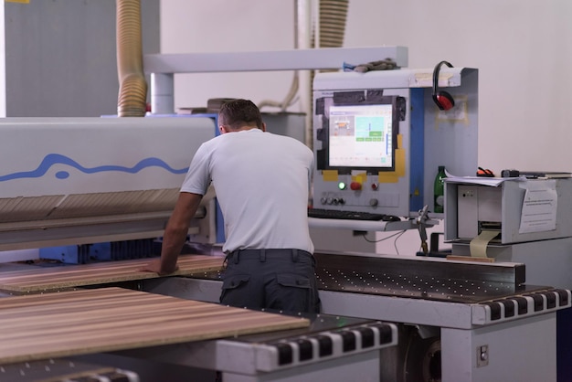 Junger Arbeiter arbeitet in einer Fabrik zur Herstellung von Holzmöbeln